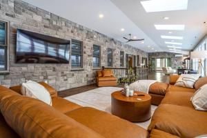 a living room with couches and a tv on a stone wall at Huge Equestrian Estate Indoor Pool, Theater, Game Rm in Schoharie