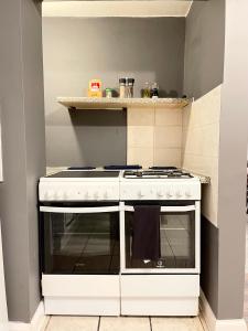 a white stove top oven in a small kitchen at Shepherds House - 3 bedroom in Goodmayes