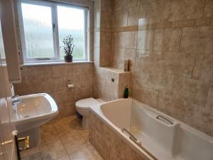 a bathroom with a tub and a toilet and a sink at Relaxing coastal getaway in Mortehoe, Woolacombe in Mortehoe +15 photos