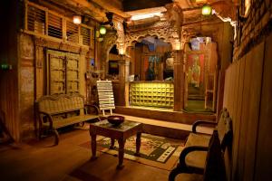 un soggiorno con tavolo, panca e finestra di Castle View Haveli a Jodhpur