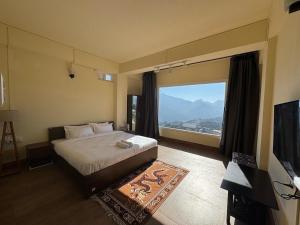 a bedroom with a bed and a large window at The Khaar in Tawang