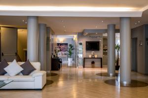 un soggiorno con divano bianco e colonne di Hotel Executive a Siena