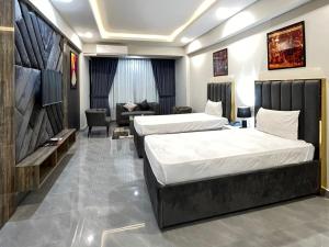 a hotel room with two beds and a couch at Hotel de Papae in Islamabad