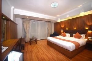 una camera da letto con un letto grande e una scrivania di Hotel Mums Home a Kathmandu