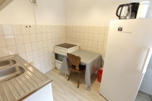Una pequeña cocina con una mesa y un refrigerador. en City-Wohnung 12a, en Brühl
