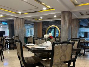 a dining room with tables and chairs and a mirror at Hotel de Papae in Islamabad