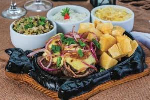 une assiette de nourriture avec un sandwich, des frites et des dips dans l'établissement Pousada Colina dos Flamboyants, à Cerro-Corá