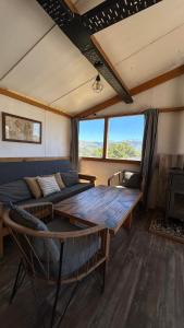 a living room with a couch and a table at Cuatro Vientos Patagonia - Lago Huechulafquen in Junín de los Andes