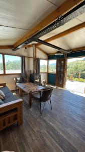 a living room with a table and a couch at Cuatro Vientos Patagonia - Lago Huechulafquen in Junín de los Andes