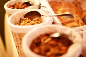 un groupe de bols de nourriture avec une cuillère dans l'établissement Hotel Casa da Calçada Relais & Chateaux, à Amarante