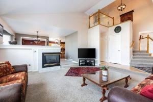 Una sala de estar con un sofá y un televisor. en Wasatch Oaks Retreat, en Cottonwood Heights