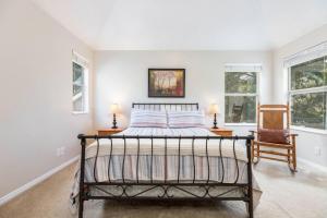 Un dormitorio con una cama y una silla y ventanas. en Clover Spring Wasatch Refuge, en Cottonwood Heights