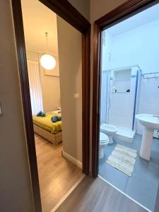 a bathroom with a toilet and a sink and a bedroom at "Marcello's Home" in Catania