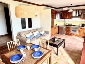 a kitchen and living room with a table and a couch at 01 Terracos de Benagil 1 - Casa Beleza in Benagil