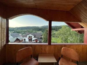 a room with a large window with a table and chairs at la VILLA in Borsa