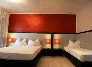 a hotel room with two beds and two lamps at La Casa Degli Angeli - Agli Angeli Ristorante Pizzeria in Pertegada