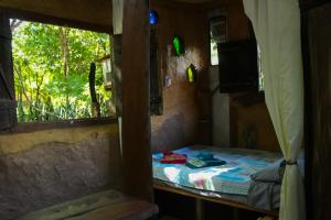a small room with a bed and a window at A Casinha do Forneiro in Bonito