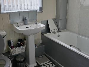 a bathroom with a sink and a toilet and a bath tub at Open planned apartment in Birkenhead +6 photos