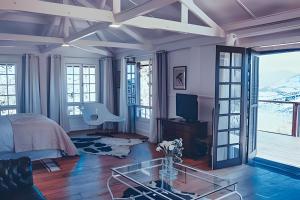 a bedroom with a bed and a glass table at Casa do Sol, Charme e Conforto na Serra Velha in Campos do Jordão
