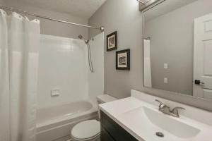 a bathroom with a sink and a toilet and a mirror at Ozark Lakeview Penthouse 3bed 3bath Condo in Osage Beach Escape in Osage Beach +27 photos
