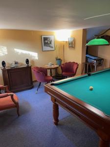 a living room with a pool table and chairs at La chambre d hôtes By Georges in Scharrachbergheim Irmstett