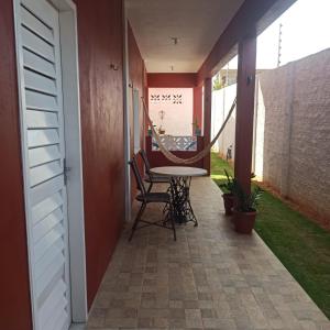 a porch with a table and chairs on a patio at Refúgio da Major in Aracati
