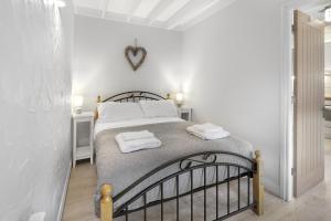 a bedroom with a bed with two towels on it at Minnows Rest - North East Escapes in Seahouses