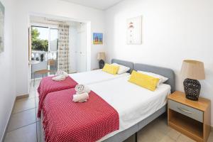 a bedroom with two beds with a red blanket at Casa Sentosa in Carvoeiro +16 photos