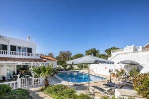 a villa with a swimming pool and a house at Casa Sentosa in Carvoeiro