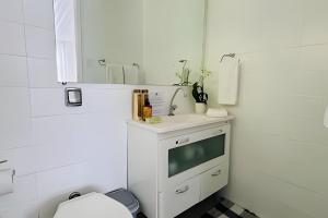 a white bathroom with a sink and a mirror at White House Campos do Jordão in Campos do Jordão