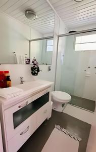 a bathroom with a sink and a toilet and a mirror at White House Campos do Jordão in Campos do Jordão