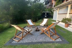 three lounge chairs and a fire pit in a yard at White House Campos do Jordão in Campos do Jordão
