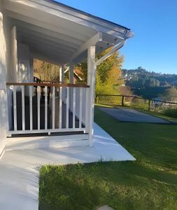 a white porch with awning on a lawn at White House Campos do Jordão in Campos do Jordão