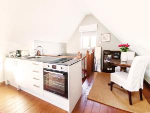 a kitchen with a stove and a dining room with a table at Little Dene Lodge by The Suffolk Cottage Collection in Pakenham