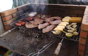 ein Haufen Fleisch und Gemüse auf einem Grill in der Unterkunft La Casa de la Cascada in Anna