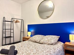 Dormitorio azul con cama y espejo en LE DONZELOT, en Rennes 8 fotos más