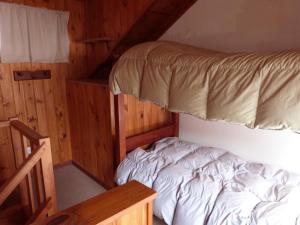ein Schlafzimmer mit einem Bett in einer Holzhütte in der Unterkunft Rudecindo Roca 1 in San Martín de los Andes