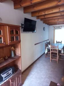 ein Wohnzimmer mit einem Flachbildfernseher an der Wand in der Unterkunft Rudecindo Roca 1 in San Martín de los Andes