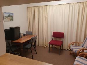 a room with a table and chairs and a television at Betty's Bay Quaint Cottage in Bettyʼs Bay