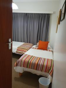 two twin beds in a room with a window at Betty's Bay Quaint Cottage in Bettyʼs Bay