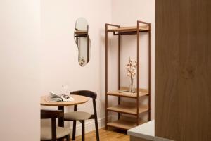 a room with a table and chairs and a mirror at Bob W London Olympia in London +41 photos