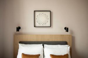 a bedroom with a bed with white pillows and a picture on the wall at Bob W London Olympia in London