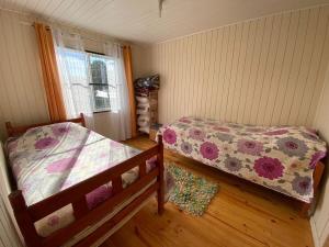 a bedroom with two beds and a window at Cabaña en Mechaico, 10 min Ancud in Ancud