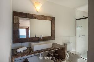 a bathroom with a sink and a mirror and a toilet at Casa com vista p mar em Garopaba PSV000 in Garopaba +23 photos