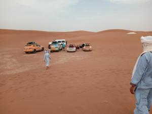 un grupo de autos estacionados en el desierto en Across Sahara, en Bou Nou