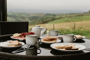 un tavolo con tazze e piatti di cibo sopra di Luxury 1 bedroom Glamping Cabin with Hot Tub & BBQ a Ballyvoy