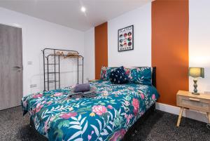 ein Schlafzimmer mit einem Bett mit einer bunten Bettdecke in der Unterkunft Chapel Street Apartments - Great Transport & Local Amenities in Long Eaton