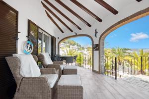 a living room with chairs and a balcony with a view at Rodolfo in Jávea