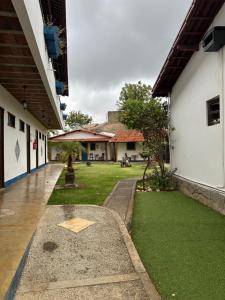 une cour d'un immeuble avec une pelouse verte dans l'établissement Pousada Colina dos Flamboyants, à Cerro-Corá
