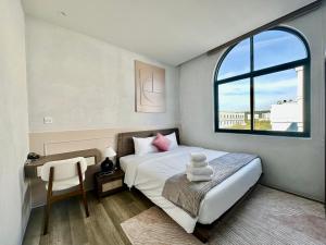 a bedroom with a bed and a desk and a window at Meridian apartment service at Marina Long beach Phu Quoc in Phú Quốc +31 photos
